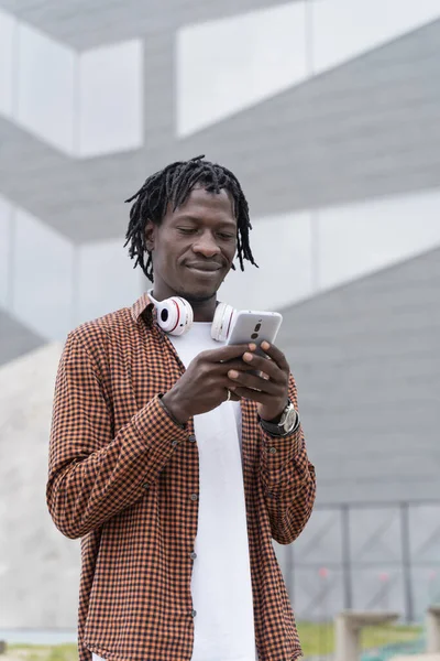 Casual African Man Bruker Smarttelefon Til Skrive Meldinger Eller Sjekke – stockfoto