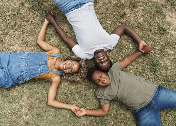 Afrikkalainen amerikkalainen perhe liimaus makaa nurmikolla — kuvapankkivalokuva