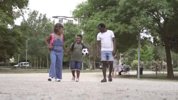 Afro-Amerikaanse ouders wandelen nemen kind terug naar basisschool — Stockvideo