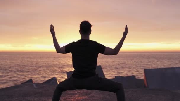 İnsan silueti gün doğumunda okyanus denizinin önünde yoga egzersizleri yapıyor. — Stok video