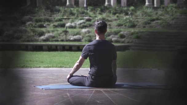 Mann übt Meditation und Entspannung auf einer Matte im Tempelgarten -Spirituell gesunde Yoga-Routine — Stockvideo