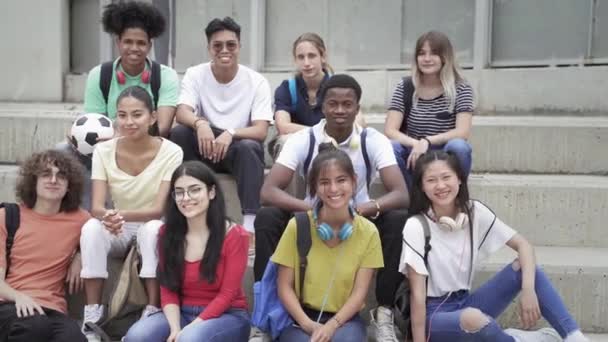 Sekelompok teman remaja multirasial melihat ke kamera. Happy Multi siswa etnis di Sekolah Menengah duduk di tangga taman bermain. Keanekaragaman etnis dalam Pendidikan dan Masyarakat — Stok Video