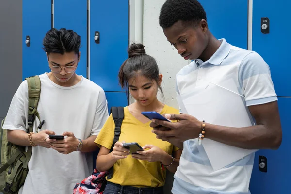 Tenåringsstudenter som bruker smarttelefoner i high school-ferier - problemer med avhengighet av sosiale medier for unge generasjoner – stockfoto