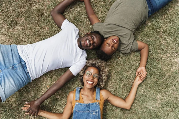 Perhe makaa nurmikolla. Happy Young Afrikkalainen Amerikan mustat vanhemmat rakastavat poikaansa — kuvapankkivalokuva