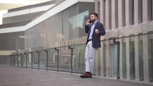 若い中東のビジネスマンは 現代の企業ビジネス地区で電話で話しています 市内のカジュアルな若いアラブの専門家のエグゼクティブ — ストック動画