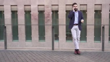 Orta Doğu 'lu genç bir iş adamı modern bir iş bölgesinde telefonla konuşuyor. Şehirde gelişigüzel genç Arap profesyonel yönetici