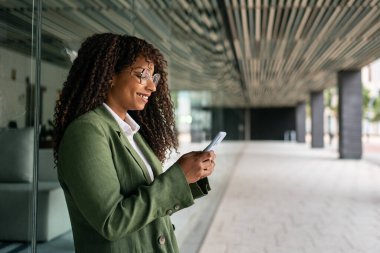 Young black African American business woman of new creative modern company working with mobile phone in office area