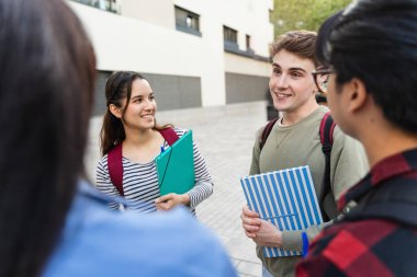 Şehirdeki şehir kampüsünde konuşan üniversite öğrencileri - dersten sonra arkadaşları olan İspanyol üniversiteli kız