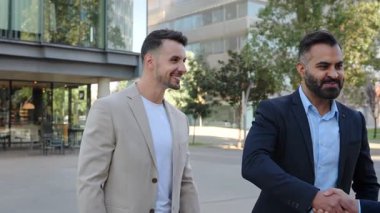 İspanyol, Hintli ve Ortadoğu iş ortakları el sıkışıyor ve açık havada bir anlaşma tartışıyorlar.