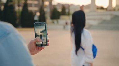 Yaz tatillerinde gülümseyen Asyalı kadın, cep telefonu fotoğraflarına poz veriyor.