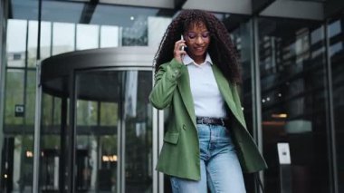 İşten çıktıktan sonra işten eve yürüyerek dönen mutlu bir iş kadını. Afro-Amerikan kadın profesyonel