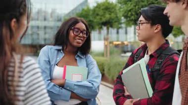 Şehirdeki şehir kampüsünde konuşan bir grup üniversite öğrencisi - derslerden sonra arkadaşları olan Afrikalı Amerikalı kız