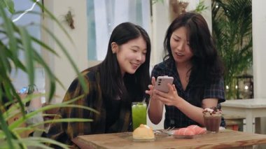 Arkadaşlar birlikte eğleniyor, akıllı telefonlara bakıyor ve gülüyorlar.