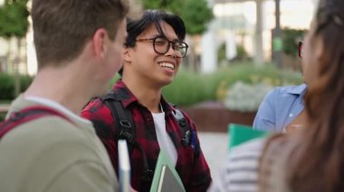 Asyalı üniversite öğrencisi, ders sonrası üniversite arkadaşlarıyla konuşuyor.