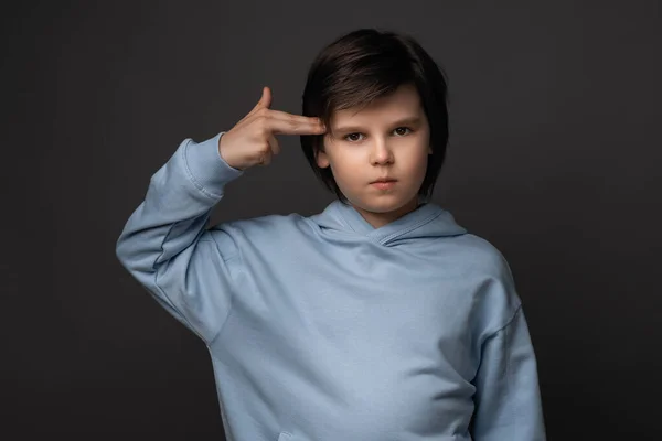Μπερδεμένο Αγόρι Ετών Ντυμένο Καθημερινά Ρούχα Δείχνει Δάχτυλα Στο Κεφάλι — Φωτογραφία Αρχείου
