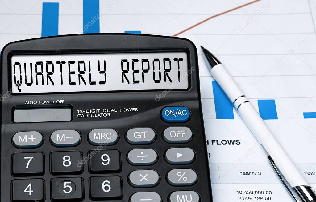 Calculator with the word quarterly report on the display. Money, finance and business concept
