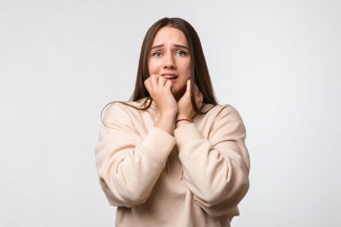 - Korkuyorum. Korku, fobi, panik atak, korku. Uzun kestane rengi saçlı, şık bej kapüşonlu, beyaz arka planda soyutlanmış korkmuş kadının portresi.