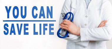 Beyaz bir arkaplanda hayat kurtarabileceğini mesaj at. Yakınlarda beyaz önlüklü ve steteskoplu bir doktor var. Tıbbi konsept
