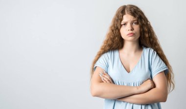 Beyaz arka planda izole edilmiş kıvırcık saçlı dalgın bir kız. İnsanların yaşam tarzı konsepti. El ele tutuşup kameraya bakıyorduk. Metnin için boşluk kopyala