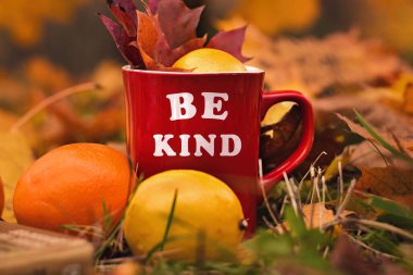 Words Be kind written on red mug. Selective focus and noise. Shallow depth of field on the mug clipart