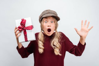 12-15 yaşlarındaki çekici sarışın kız kurdeleyle süslenmiş, şaşırmış yüz ifadesiyle poz veriyor. Stüdyo beyaz arka plan çekti, izole. Yeni Yıl, Kadınlar Günü, Doğum günü, Tatil konsepti