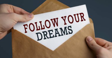 Mavi arka planda rüyanız ve iletişim konseptiyle ilgili bir yazı bulunan erkek el sanatları zarfı.