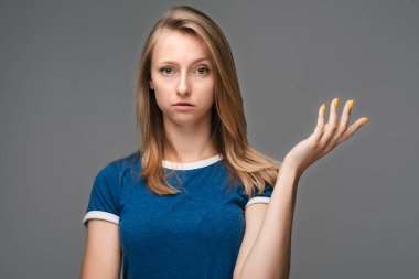 What the hell are you talking about, nonsense. Studio shot of frustrated female with blonde straight hair gesturing with raised palm, frowning, being displeased and confused with dumb question