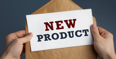 Erkek eller el sanatları zarfını mavi arka planda NEW PRODUCT, iletişim konsepti ile tutuyor