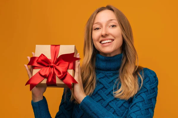 Imagen Encantadora Mujer Joven Suéter Punto Cálido Sonriendo Sosteniendo Regalo —  Fotos de Stock