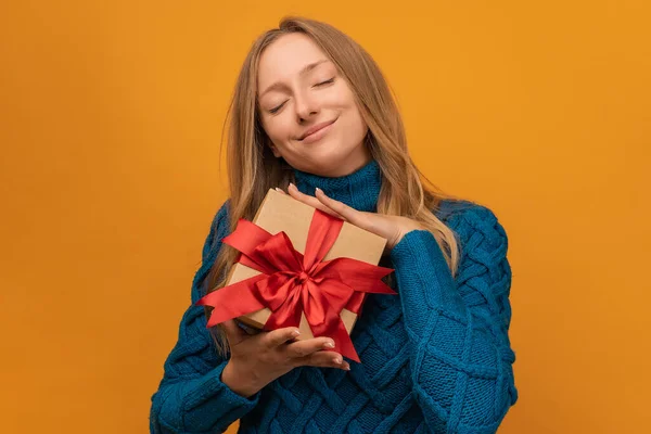 Imagen Encantadora Mujer Joven Suéter Punto Cálido Sonriendo Sosteniendo Regalo —  Fotos de Stock