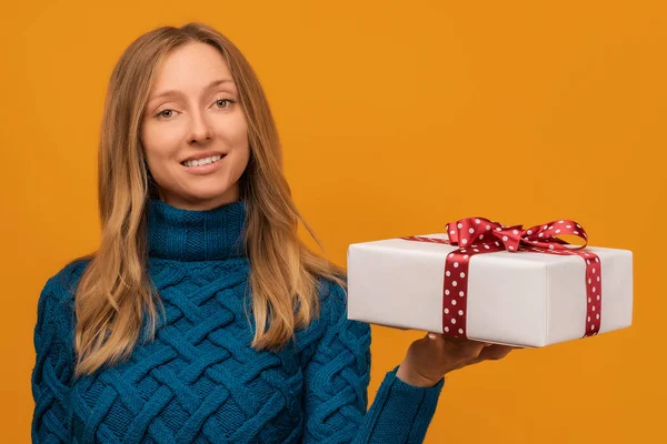 Imagen Encantadora Mujer Joven Suéter Punto Cálido Sonriendo Sosteniendo Regalo —  Fotos de Stock