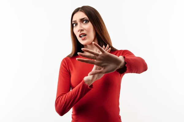 手を挙げて嫌悪反応が上がるのでカジュアルな赤いセーターを着た長い栗色の髪をした不満な少女のイメージ スタジオショット 白の背景 表情コンセプト — ストック写真