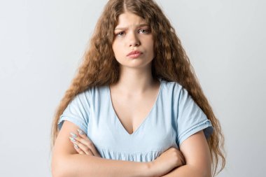 Beyaz arka planda izole edilmiş kıvırcık saçlı dalgın bir kız. İnsanların yaşam tarzı konsepti. El ele tutuşup kameraya bakıyoruz..