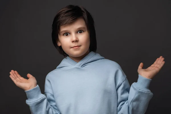 Bunun olabileceğini kim bilebilirdi ki? 10-12 yaşlarında hoş bir çocuğun portresi, günlük kıyafetler giymiş, avuçlarını silkmiş ve gülümsüyor, özür diliyor. Stüdyo gri arka plan çekti. Yüz ifadesi kavramı