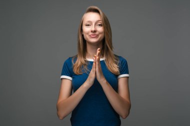 Kırıcı sözlerle şaşırmış genç sarışın kadın kendini işaret parmağıyla işaret ediyor sorgulama ifadesi var, mavi tişört giyiyor. İnsani duygular, yüz ifadesi kavramı.