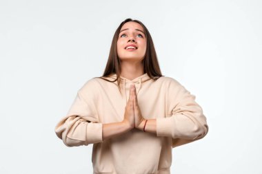 Uzun saçlı, mutlu esmer bir kadının resmi. Gülümseyen ve avuçlarını bir arada tutan sıradan kıyafetler giymiş bir kadın. Meditasyon yapıyor, barış ve sevgi için dua ediyor, sakin ve huzurlu bir yüz ifadesi var.