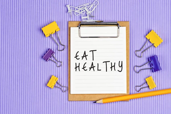 Die Worte Eat Healthy Stehen Auf Einem Weißen Notizbuch Nahaufnahme — Stockfoto