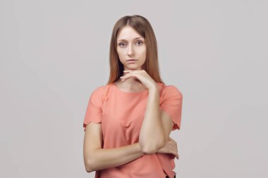 Bir düşüneyim. Düşünceli bir suratı olan, eli çenesinde bir şeyler planlayan ya da seçim yapan dalgın sarışın bir kız. Stüdyo çekimi, gri arkaplan