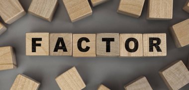 Tahta küplerden yapılmış FACTOR kelimesi. Kavramsal fotoğraf. Üst görünüm