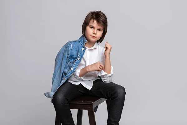 Przystojny Chłopiec Modzie Lat Siedzi Krześle Studio Ubrany Białą Koszulę — Zdjęcie stockowe