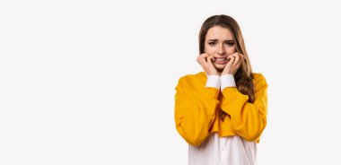 Korkmuş esmer kızın portresi, el ele tutuşmuş, korkudan titreyen, ürkütücü sesten çok korkan, beyaz arka planda sersemlemiş bir şekilde duran. Kopyalama alanı oluştur