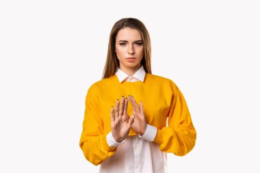 Uzak dur ve beni rahat bırak. Şiddetli mutsuz esmer kız yeterince gösteriyor ya da jesti durduruyor, antipati gösteriyor, teklifi reddediyor. Stüdyo çekimi, beyaz arkaplan