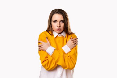 Esmer kız soğuk, üzgün ya da hasta olduğu için kendine sarılıyor. Stüdyo çekimi, beyaz arkaplan