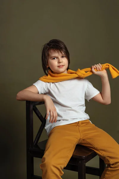 Stilig Mode Ung Pojke Sitter Stol Studio Grön Bakgrund Tillfällig — Stockfoto