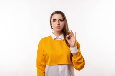 Çekici esmer kız portresi gündelik giysiler içinde. Elle iyi niyet göstergesi. İnsani duygular, jest kavramı. Stüdyo çekimi, beyaz arkaplan