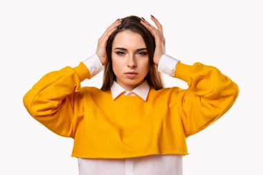 Endişeli, endişeli ve endişeli esmer kızın portresi, başını kavrayıp panikleyen, paniğe kapılan, korkmuş ve gergin hisseden, ne yaptığını bilmeyen. Stüdyo çekimi, beyaz arkaplan