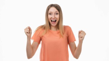 Mutlu sarışın kız yumruklarını sıkar ve evet diye bağırır zaferi kutlar, hedefe ulaşır. İnsani duygular, yüz ifadesi kavramı. Stüdyo çekimi, beyaz arkaplan