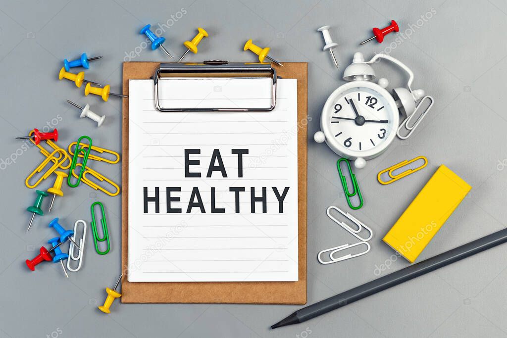 The words Eat Healthy written on a white notebook. Closeup of a personal agenda