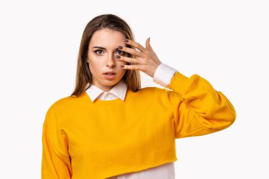 Endişeli, korkmuş esmer kız, ağzı açık bir şekilde el ele tutuşuyor. Heyecan verici bir şey duyuyorum. Beyaz arka plan.