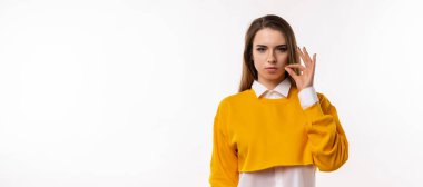 Sırların benim konseptimle güvende. Esmer kız, gündelik kıyafetleriyle fermuarlı jest yapıyor. Sanki anahtarla ağzını kapatıyor gibi. Stüdyo fotoğrafı, beyaz arka plan. Sır tut. Kopyalama alanı oluştur